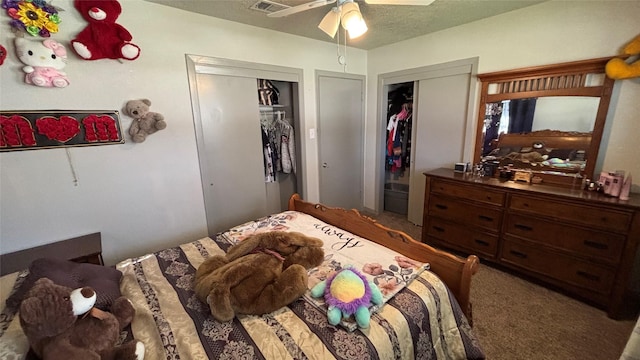 bedroom featuring ceiling fan, carpet, and two closets