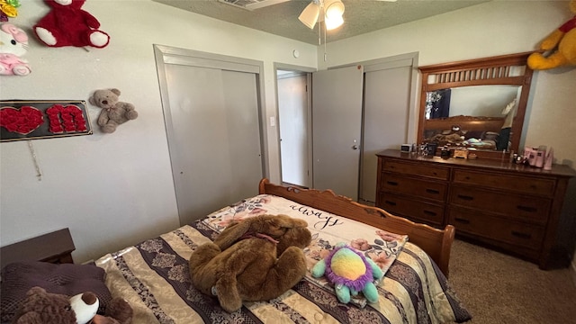 carpeted bedroom with ceiling fan and a textured ceiling