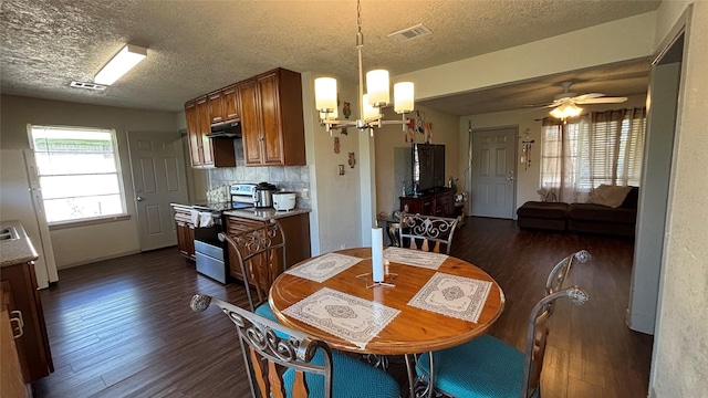 dining space featuring dark hardwood / wood-style flooring, ceiling fan with notable chandelier, and a textured ceiling