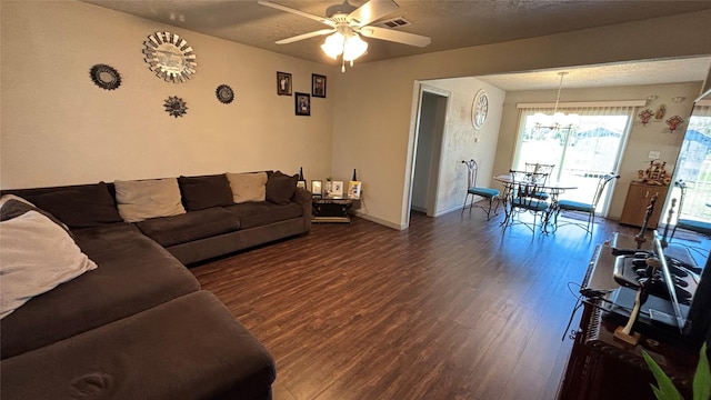 living room with a textured ceiling, dark hardwood / wood-style flooring, and ceiling fan with notable chandelier