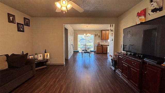 living room with ceiling fan with notable chandelier, a textured ceiling, and dark hardwood / wood-style floors