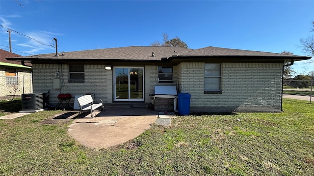 rear view of house featuring central AC unit, a yard, and a patio