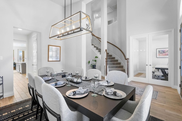 dining space with french doors, an inviting chandelier, and a high ceiling