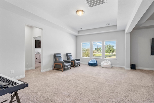 sitting room featuring carpet and a tray ceiling