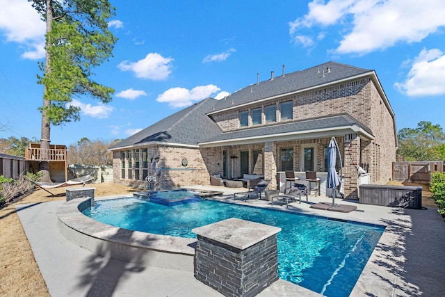 view of swimming pool featuring a patio area and an in ground hot tub