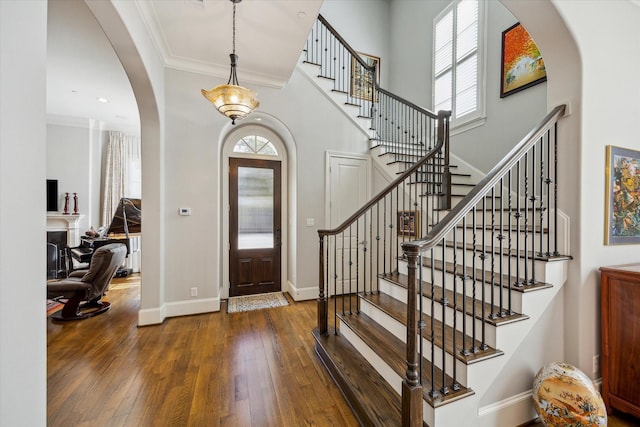 foyer featuring dark wood-type flooring and crown molding