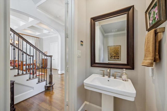 bathroom featuring hardwood / wood-style floors, coffered ceiling, beamed ceiling, crown molding, and sink