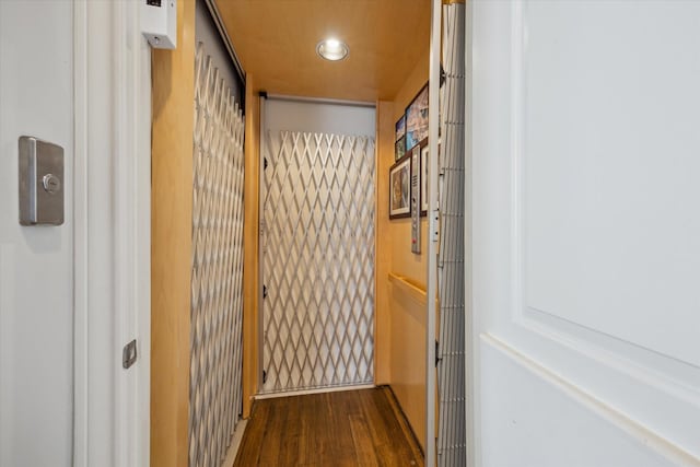 hall featuring wood finished floors and recessed lighting