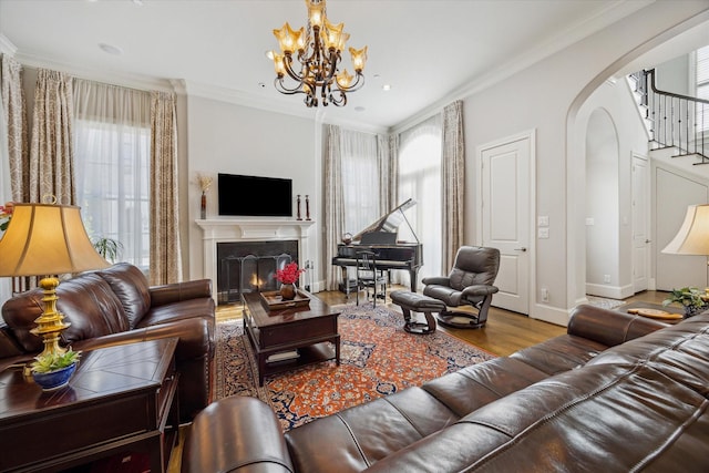 living room with wood-type flooring, crown molding, and a chandelier