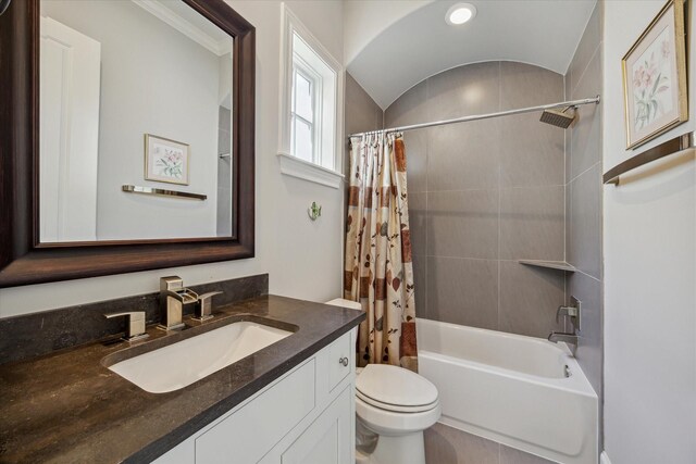 full bathroom with lofted ceiling, vanity, shower / tub combo, and toilet