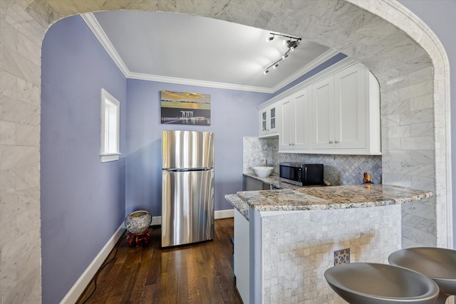 kitchen featuring crown molding, white cabinets, appliances with stainless steel finishes, and light stone counters