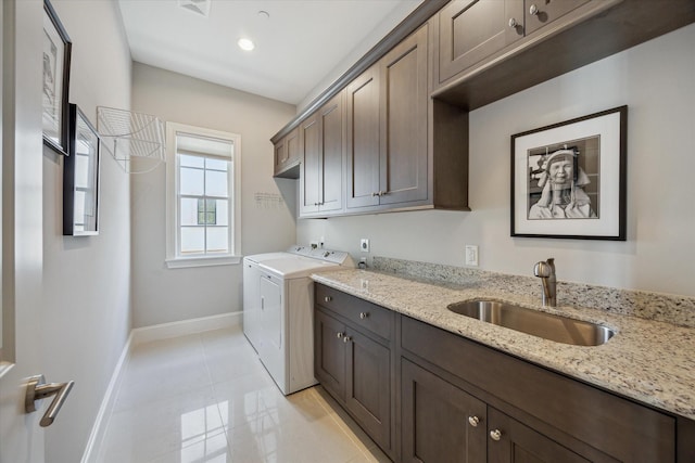 washroom featuring cabinets, independent washer and dryer, and sink