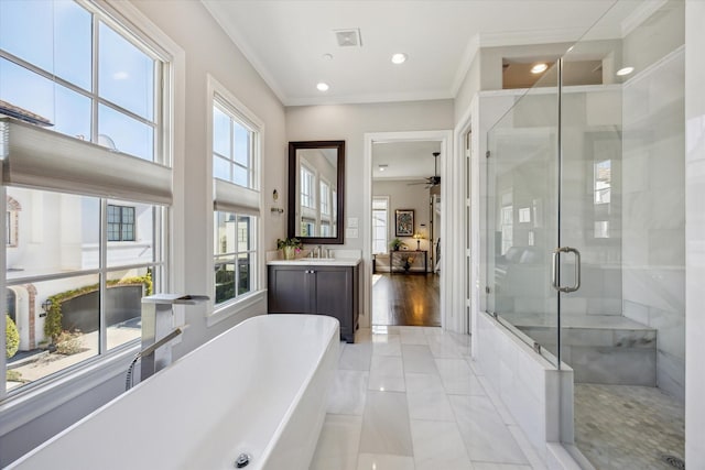 full bathroom featuring a freestanding bath, ornamental molding, a stall shower, and vanity