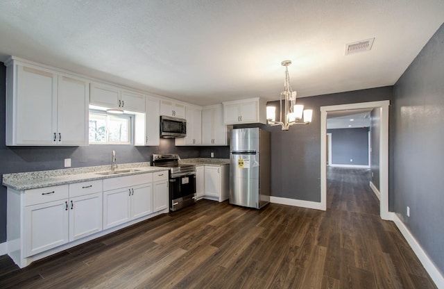 kitchen with decorative light fixtures, sink, light stone countertops, appliances with stainless steel finishes, and white cabinets