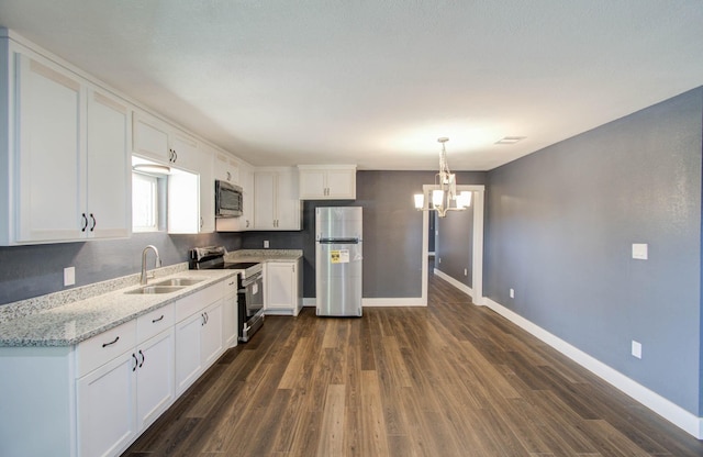 kitchen featuring stainless steel appliances, light stone countertops, pendant lighting, white cabinets, and sink