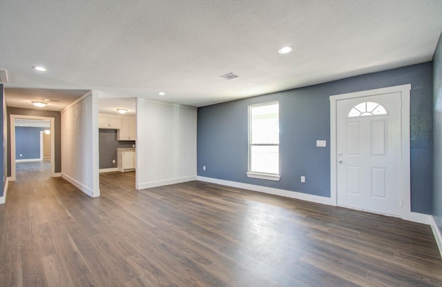 foyer with a textured ceiling and dark wood-type flooring