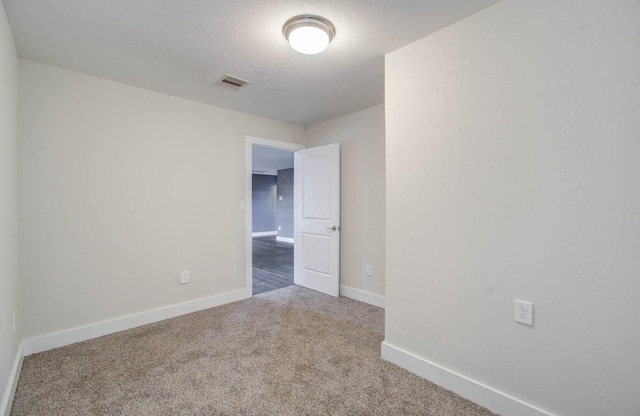 carpeted spare room featuring a textured ceiling