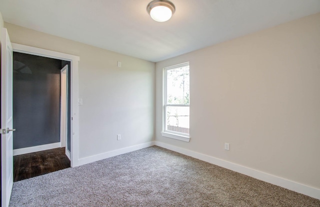 spare room with dark colored carpet