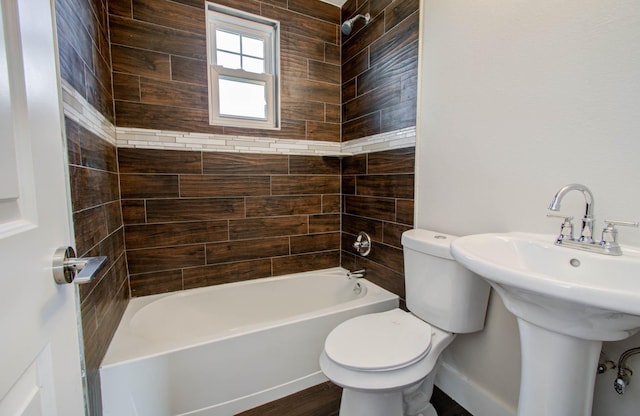 full bathroom featuring toilet, tiled shower / bath combo, and sink