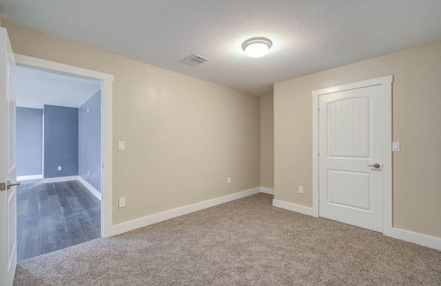 empty room featuring a textured ceiling and carpet floors