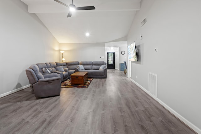 living area featuring a ceiling fan, wood finished floors, baseboards, visible vents, and beamed ceiling