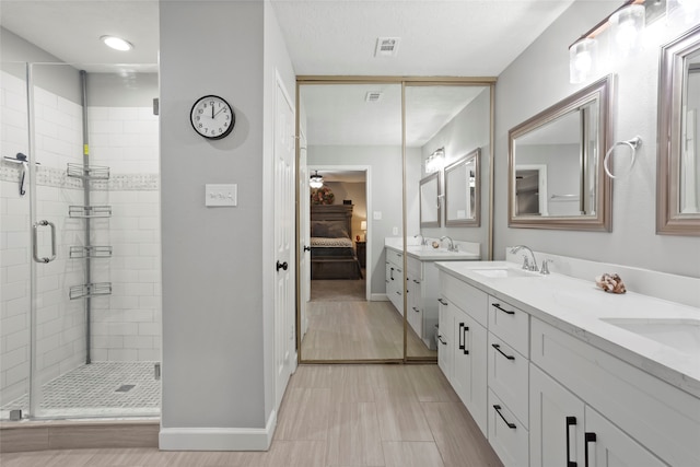 ensuite bathroom featuring ensuite bath, double vanity, a shower stall, and a sink