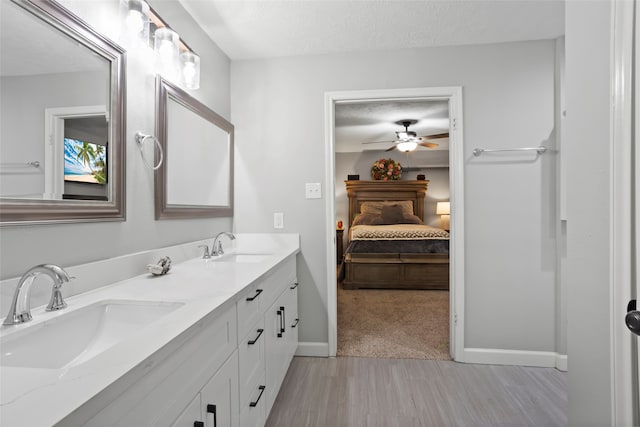 654 W Country Grove Cir, Pearland, TX 77584 - full bathroom with baseboards, connected bathroom, a textured ceiling, double vanity, and a ceiling fan