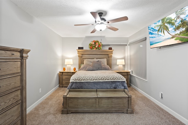 bedroom featuring light colored carpet, baseboards, and a textured ceiling