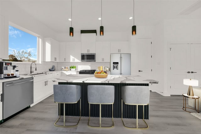 kitchen with a breakfast bar area, appliances with stainless steel finishes, sink, and a center island