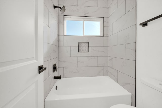 bathroom with toilet and tiled shower / bath combo