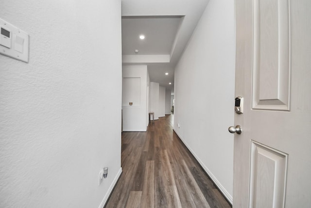 hallway featuring recessed lighting, baseboards, and dark wood-type flooring