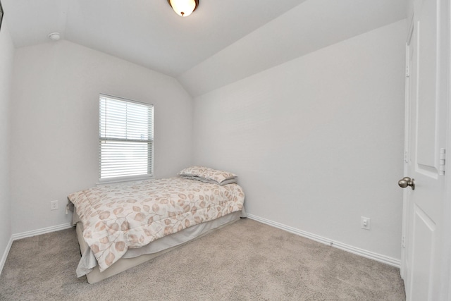 carpeted bedroom with lofted ceiling and baseboards