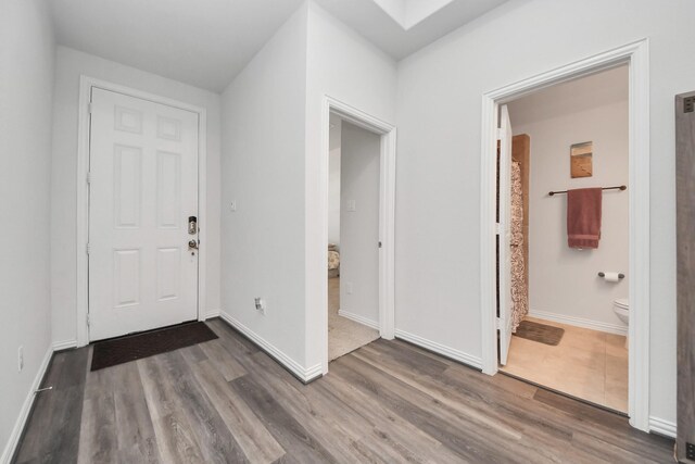 entrance foyer with dark wood-type flooring and a skylight