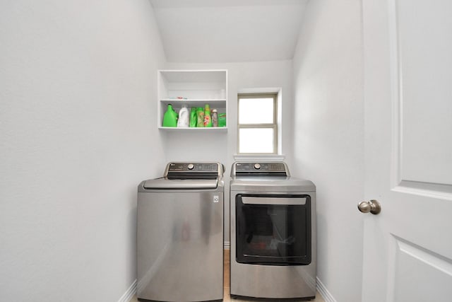 washroom with washing machine and dryer, laundry area, and baseboards