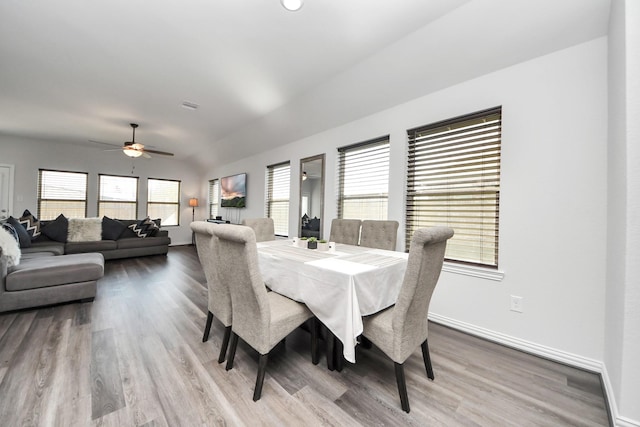 dining room with hardwood / wood-style flooring, vaulted ceiling, ceiling fan, and a wealth of natural light