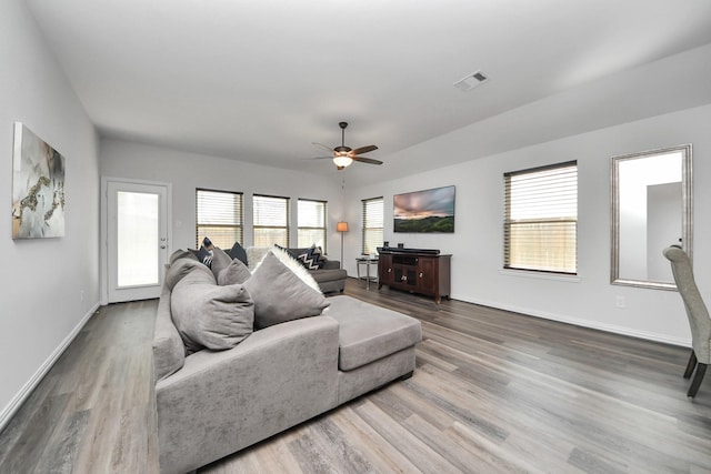 living room featuring a healthy amount of sunlight, wood-type flooring, and ceiling fan