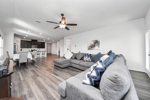 living room featuring visible vents, baseboards, recessed lighting, wood finished floors, and a ceiling fan