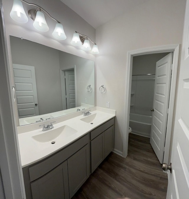 full bathroom featuring vanity, hardwood / wood-style flooring, shower / tub combination, and toilet