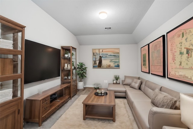 carpeted living room with vaulted ceiling