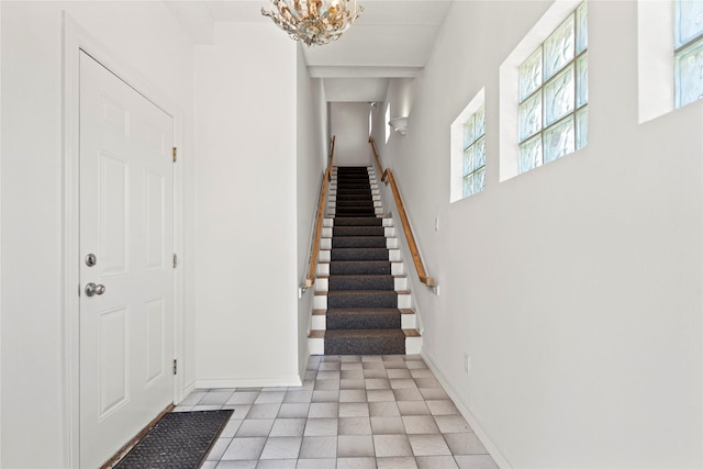 entryway featuring a healthy amount of sunlight, light tile patterned floors, and an inviting chandelier