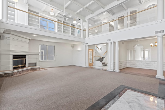 unfurnished living room featuring ceiling fan with notable chandelier, carpet flooring, a towering ceiling, and coffered ceiling