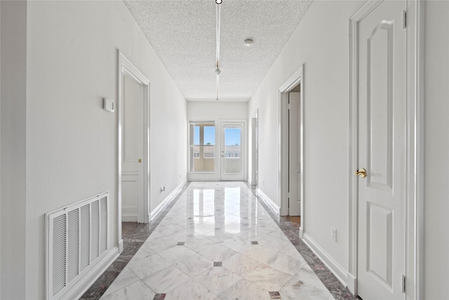 hall with a textured ceiling