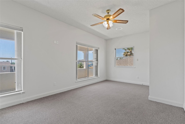 carpeted spare room with ceiling fan and a textured ceiling