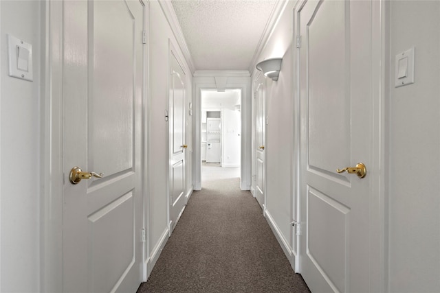 hall featuring dark carpet, a textured ceiling, and ornamental molding