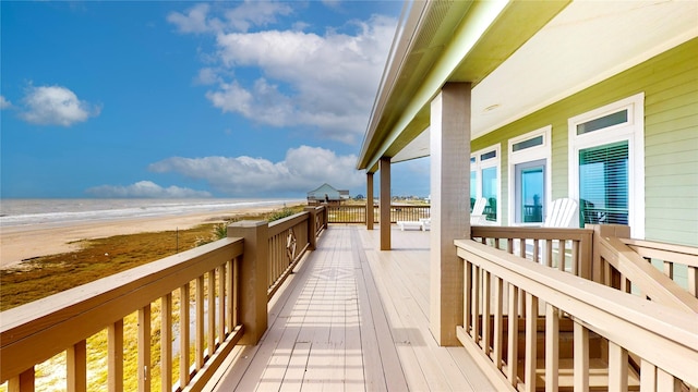 wooden deck with a view of the beach and a water view