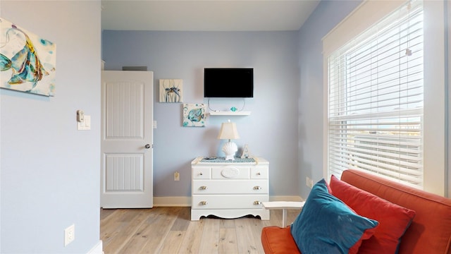 living area with plenty of natural light and light hardwood / wood-style flooring