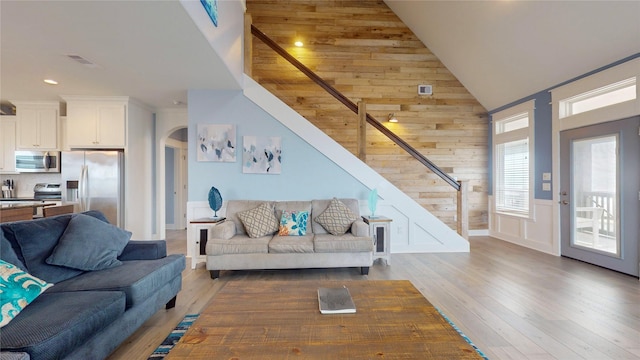 living room with high vaulted ceiling and wood-type flooring