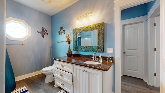 bathroom featuring toilet, hardwood / wood-style flooring, and vanity