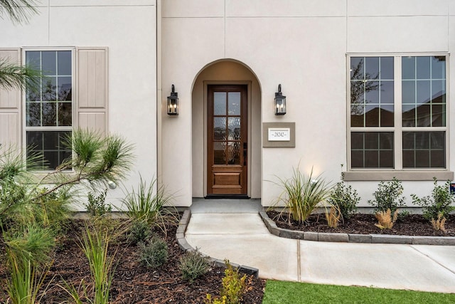 doorway to property featuring stucco siding