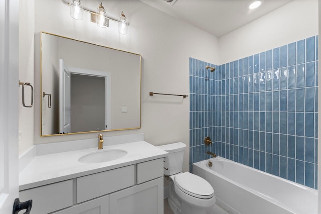 full bathroom with vanity, tiled shower / bath combo, and toilet